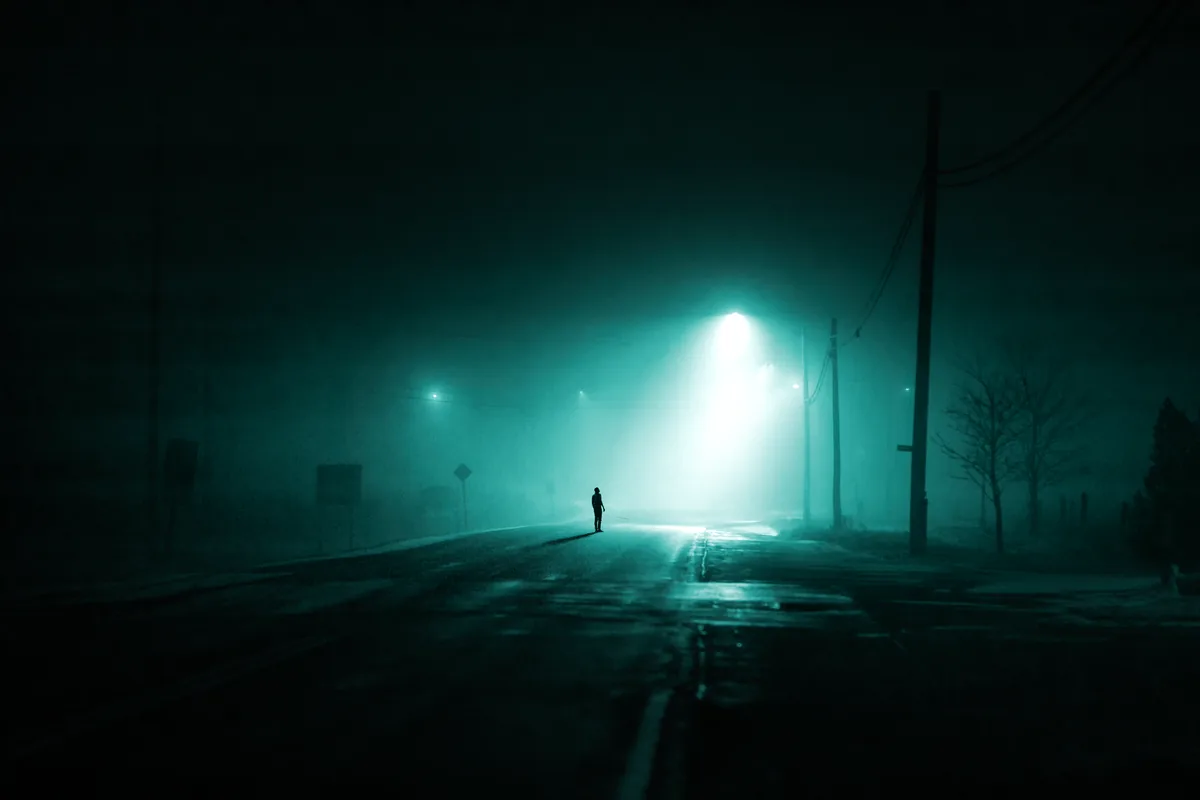 A lone figure standing under a single streetlight on a foggy country road at night in rural Ontario