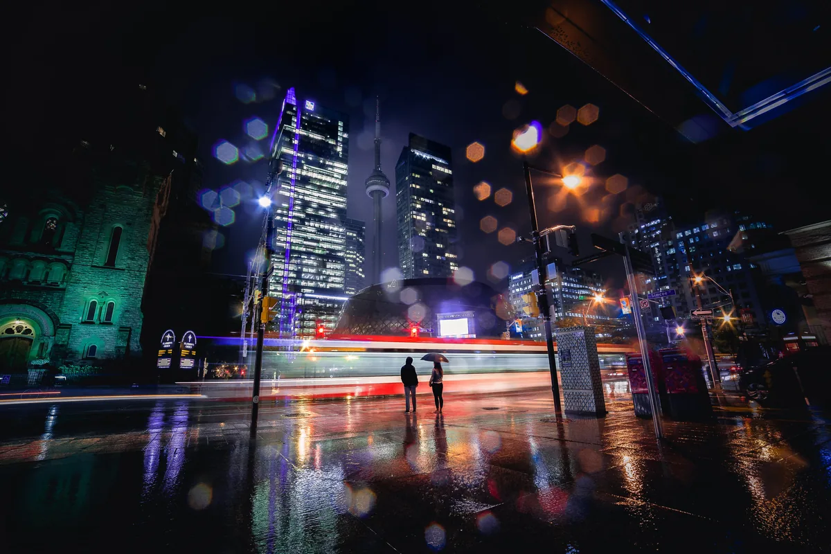 Toronto city lights at night dissolving into soft bokeh above a street
