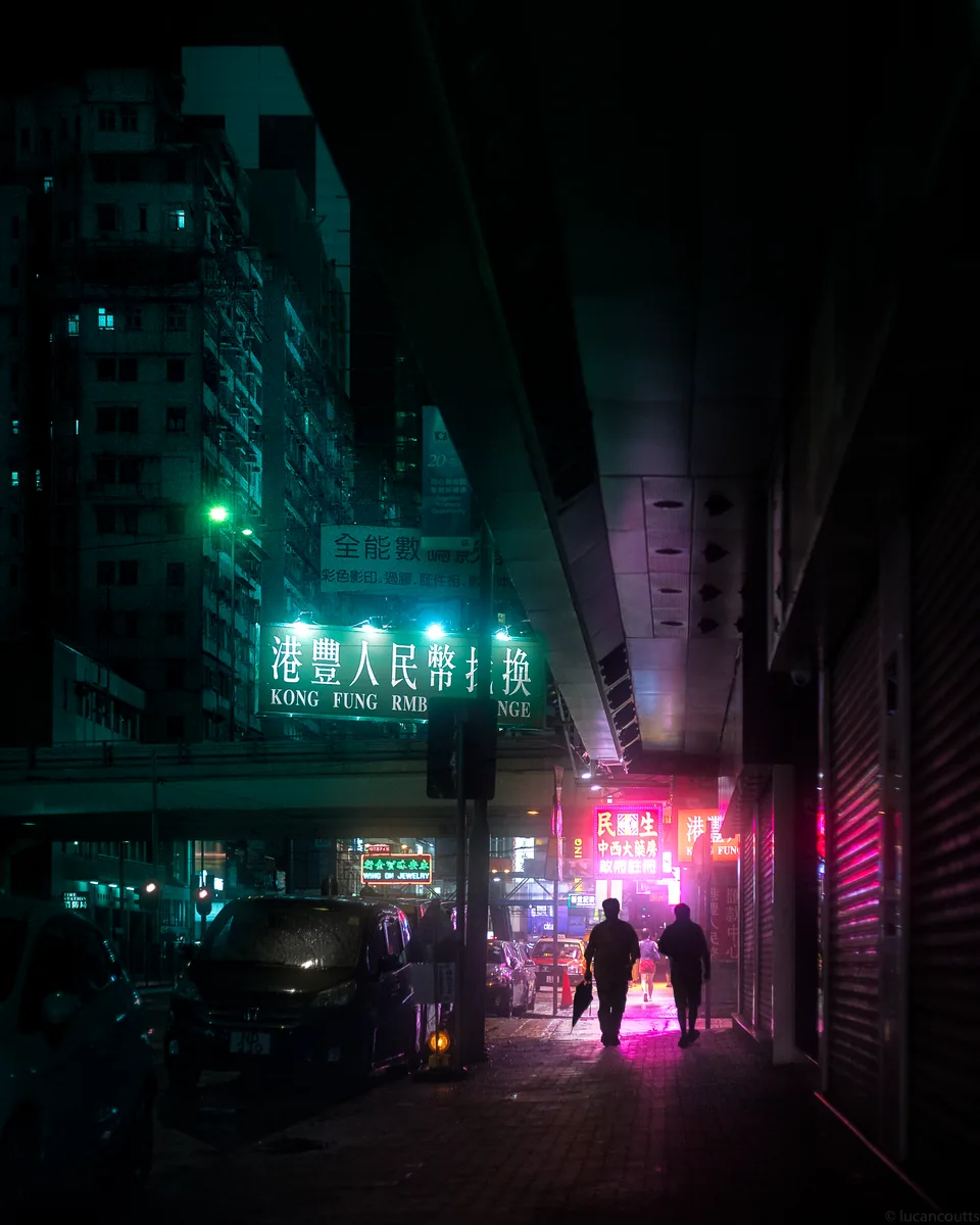 A dark alley in Wan Chai, Hong Kong, with pink neon glowing at the far end